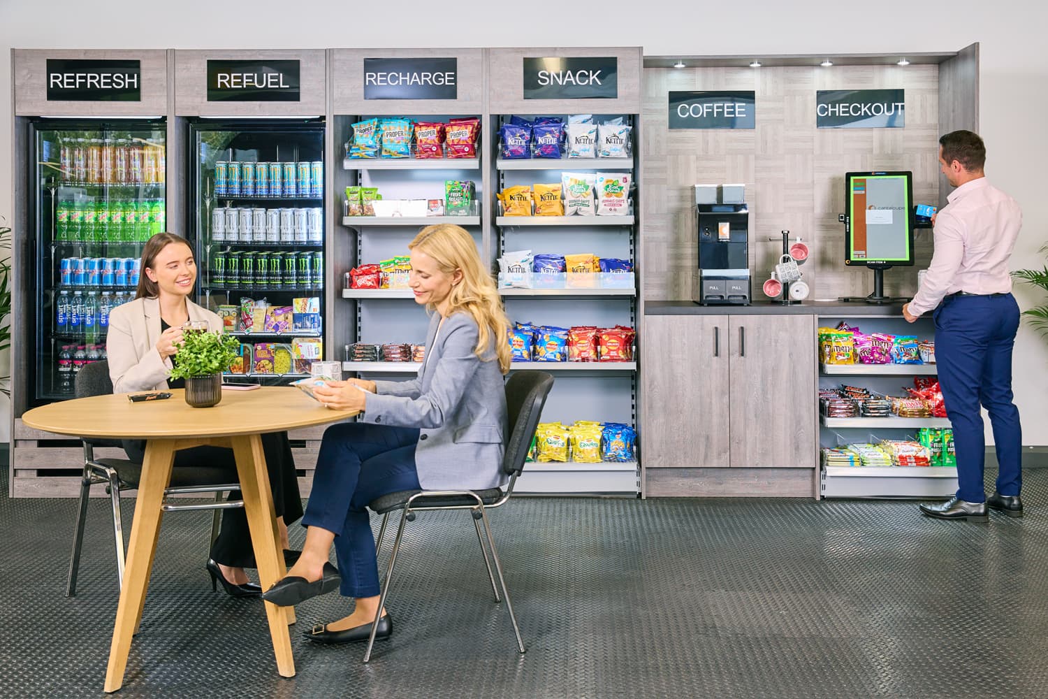 Coworkers using a modern workplace micro market and self-checkout station
